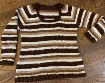 May include: A brown, white and beige striped knitted sweater with a scoop neck.