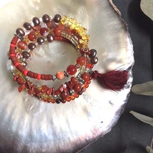 Pulsera de varias hileras con piedras semipreciosas naturales y perlas cultivadas de agua dulce, estilo boho chic en tonos naranjas y amarillos.