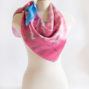 May include: A pink and blue silk scarf with a floral design and the text "Forever in Love" and "Do not be anxious about anything, but in every situation, by prayer and petition, with thanksgiving, present your requests to God."