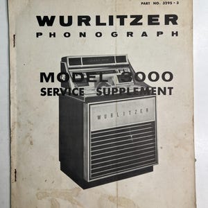 May include: A vintage off-white paper manual titled WURLITZER PHONOGRAPH MODEL 3000 SERVICE SUPPLEMENT, PART NO. 3295-3. The cover features a black and white illustration of a Wurlitzer jukebox and text identifying The Wurlitzer Company, North Tonawanda, New York.