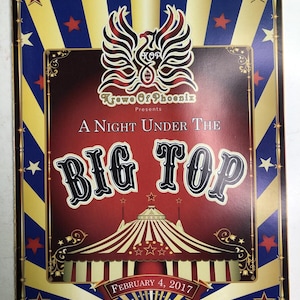 May include: A rectangular event program featuring a red, white, and blue sunburst background with stars. The text reads Krewe Of Phoenix Presents A Night Under The Big Top February 4, 2017, above a graphic of a striped circus tent and a phoenix logo.