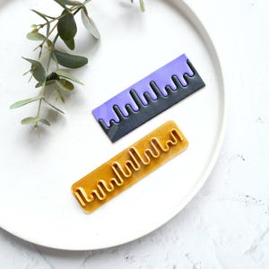 Ferramenta de textura com lâmina ondulada para argila polimérica, ideal para confecção de brincos e corte de padrões.