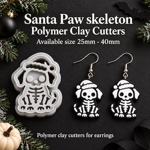 Può includere: Un tagliapasta in argilla polimerica grigio chiaro a forma di cane scheletro con cappello da Babbo Natale, insieme a un paio di orecchini a forma di cane scheletro bianco e nero con ganci argentati. Il testo recita Santa Paw skeleton.