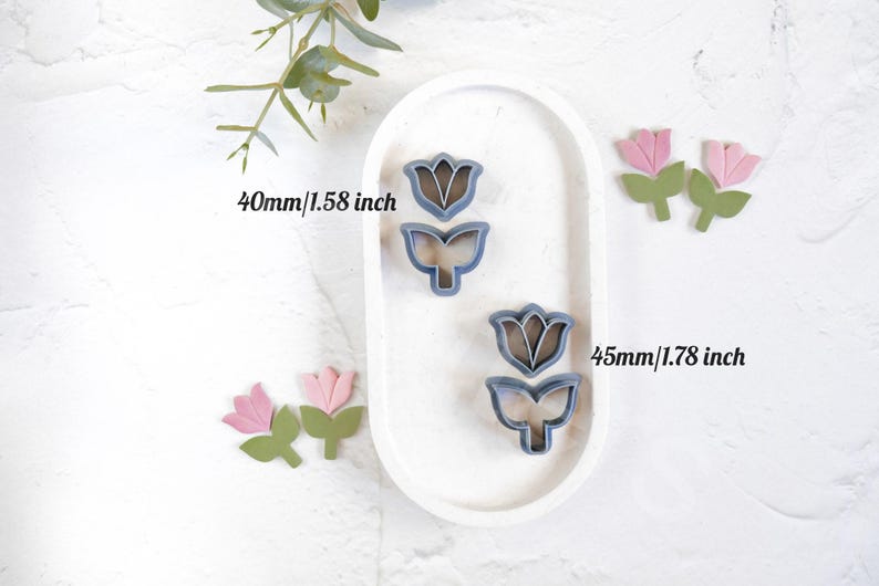 May include: Two metal cookie cutters shaped like tulips. The larger cutter is 1.78 inches tall and the smaller cutter is 1.58 inches tall.