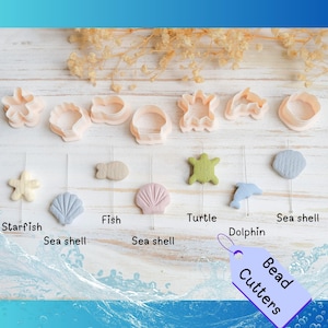 Op de afbeelding: Een verzameling kralensnijders in verschillende zeethema-vormen, waaronder zeesterren, vissen, zeeschelpen, een schildpad en een dolfijn, in pastelkleuren. De afbeelding bevat een label met de tekst "Bead Cutters".