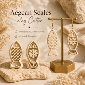 Puede incluir: Cortadores y pendientes de arcilla beige con diseño de pez. Los pendientes cuelgan de un soporte dorado. Los cortadores y pendientes con forma de pez tienen detalles de escamas y flores. El texto de la imagen dice "Aegean Scales clay Cutter" y "available size 25mm-40mm".