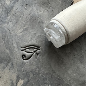 Tampon poterie oeil égyptien. Tampon pour céramique égypte. Tampon pour poterie céramique.