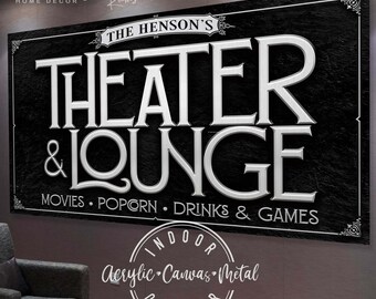 May include: Black and white sign with the text "THE HENSON'S THEATER & LOUNGE" and "MOVIES. POPCORN. DRINKS & GAMES". The sign also has the text "INDOOR Acrylic Canvas Metal OUTDOOR".