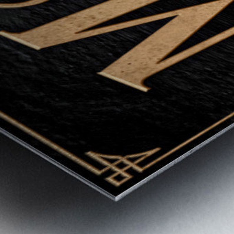 May include: A gold-colored metal sign with the word "BOOM" in large, stylized letters on a black background.