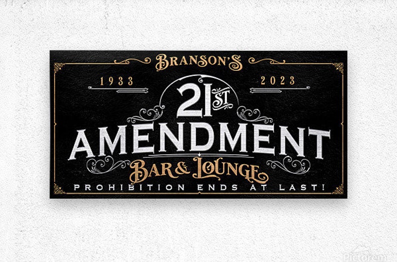May include: A black and gold sign with the text "Branson's 21st Amendment Bar & Lounge Prohibition Ends At Last!" with the years 1933 and 2023.