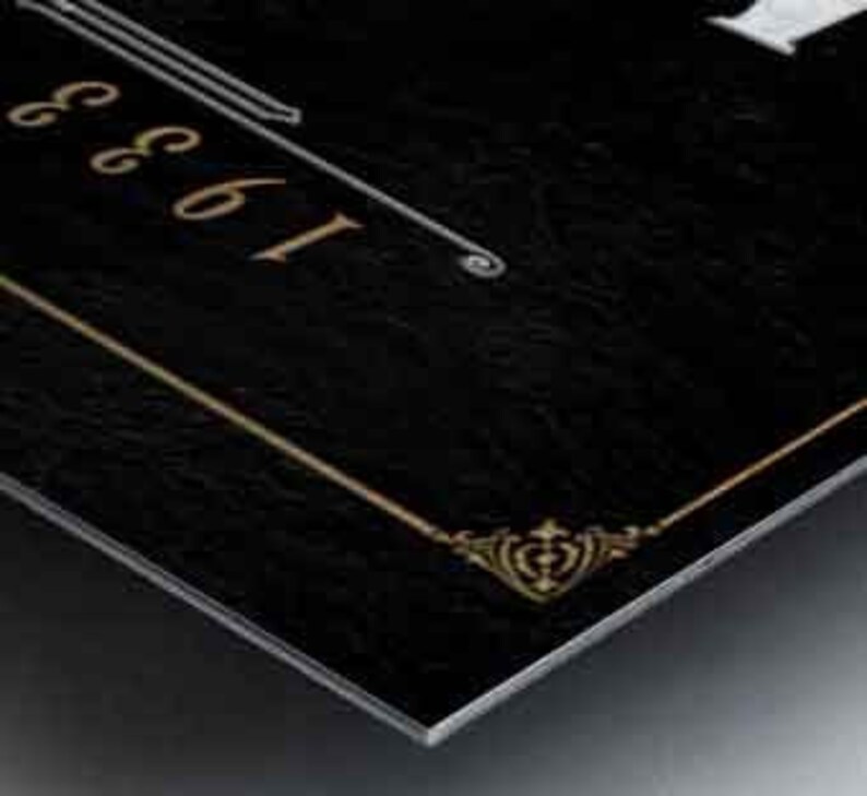 May include: A black metal sign with gold trim and the text "1961" in white.