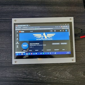 May include: A computer screen displaying the YouTube channel page for "Alans Inventions". The channel logo is a gold stylized letter "A" with wings. The channel has 3.14K subscribers and 30 videos. The screen shows the channel's home page with tabs for videos, shorts, live, playlists, community, and channel.