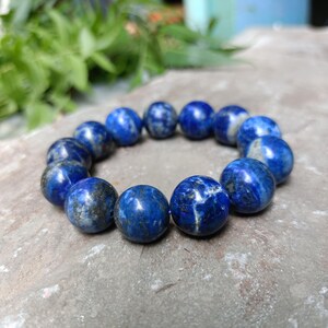 Royal blue gemstone bracelet resting on neutral fabric background