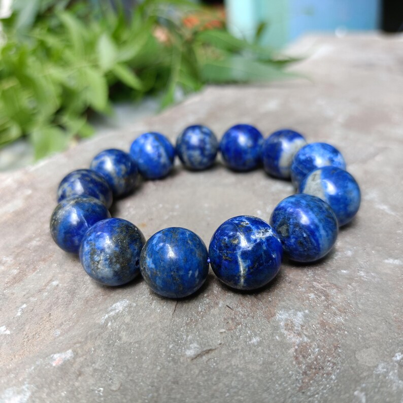 Royal blue gemstone bracelet resting on neutral fabric background