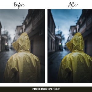 Op de afbeelding: Een persoon in een gele regenjas loopt over straat in een stad. De straat is omzoomd met gebouwen en de lucht is bewolkt.