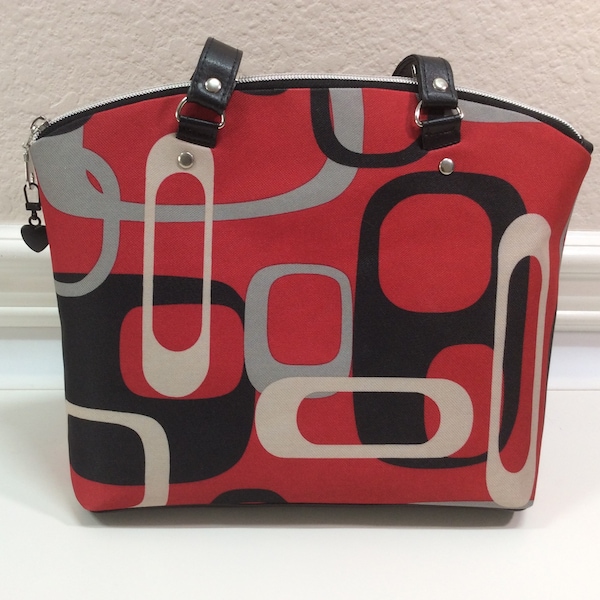 Lola shoulder bag in red, black, and gray; domed shape, top zipper closure, and fully lined in red waterproof canvas.