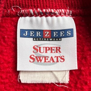 May include: A white tag with the text "JERZEES ACTIVEWEAR SUPER SWEATS" in blue and red lettering.