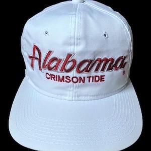 May include: White baseball cap with a red embroidered logo that says "Alabama Crimson Tide".