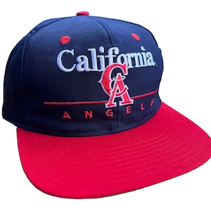 May include: A blue and red baseball cap with the words "California Angels" and a red "A" logo embroidered on the front.