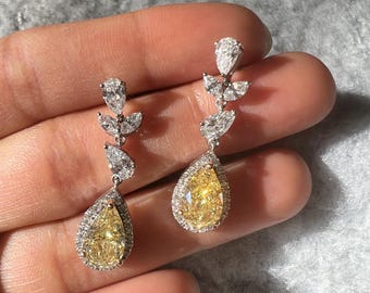 Stunning fancy yellow diamond dangle earrings with pear and marquise cute lab grown diamonds. Teardrop halo diamond earrings in solid gold.