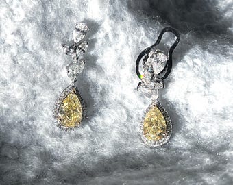 Stunning fancy yellow diamond dangle earrings with pear and marquise cute lab grown diamonds. Teardrop halo diamond earrings in solid gold.