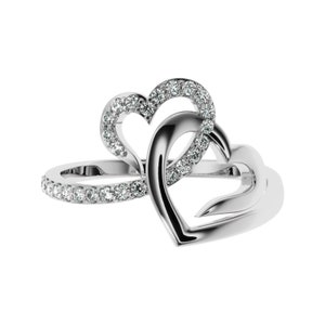 May include: A silver ring with two interlocking hearts, each heart is accented with small clear stones.