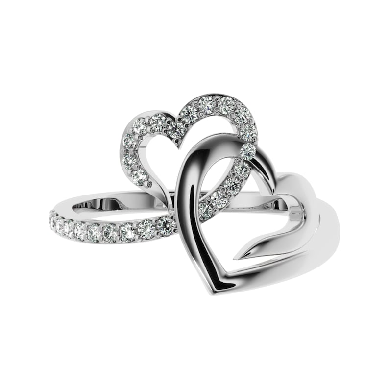 May include: A silver ring with two interlocking hearts, each heart is accented with small clear stones.