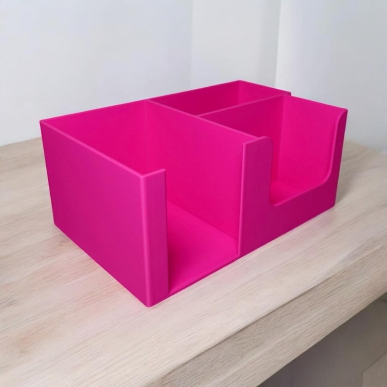 Op de afbeelding: Een felroze bureau-organizer met drie compartimenten. De organizer is gemaakt van een stevig materiaal en heeft een rechthoekige vorm. Verticale verdelers cre&euml;ren aparte opbergruimtes voor kantoorbenodigdheden.