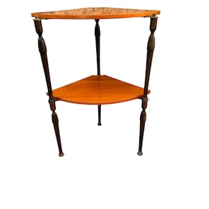 May include: A three-tiered, triangular side table with a warm wood finish. The top shelf has a textured surface, while the lower shelf is smooth. The table has dark, slender legs and brass accents, showcasing a vintage aesthetic.