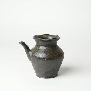 May include: A black ceramic teapot with a textured surface and a slightly flared spout. The teapot has a unique, ruffled rim.