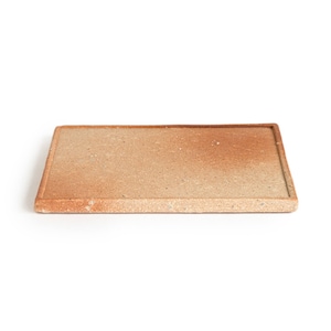 May include: A rectangular ceramic tray with a light brown glaze and a slightly raised rim. The tray has a speckled appearance and a subtle gradient of color.