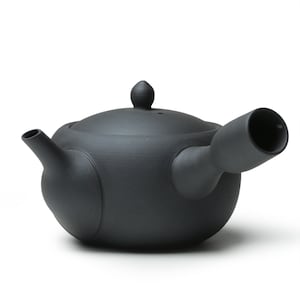May include: A black ceramic teapot with a rounded body and a spout on the side. The teapot has a lid with a small knob on top.