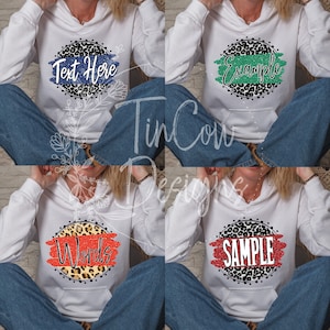 May include: Four white hooded sweatshirts with a black and white leopard print circle design. Each sweatshirt has a different colored stripe with text on it. The text on the sweatshirts reads "Text Here", "Example", "Words", and "SAMPLE".