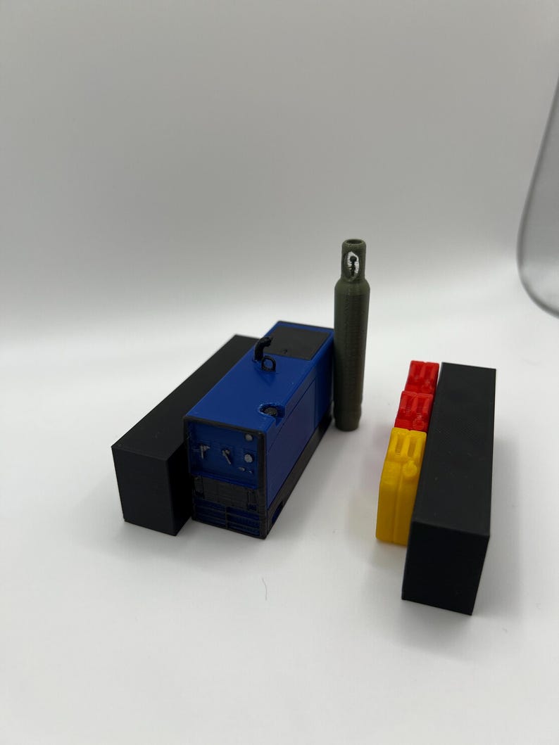 Peut inclure: Une machine &agrave; souder bleue et noire avec une bouteille de gaz verte et des blocs rouges et jaunes.