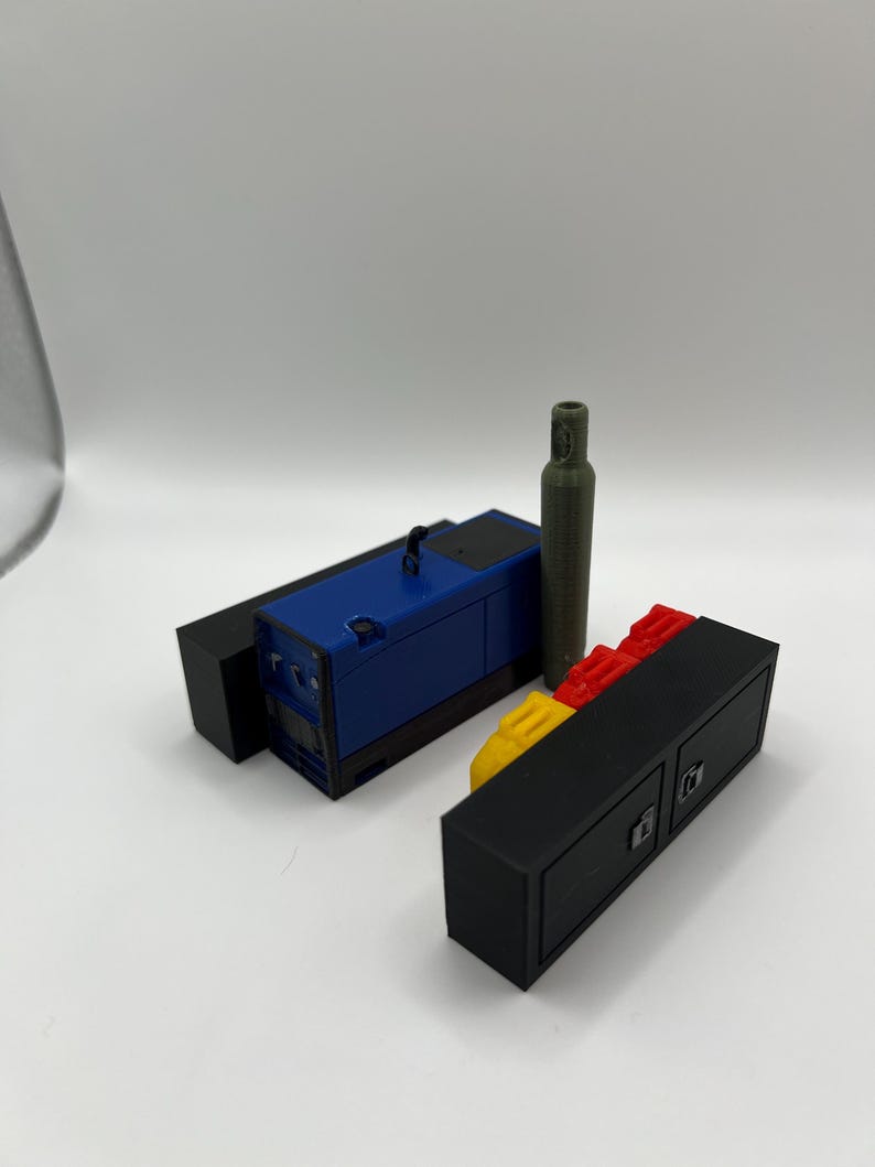 Peut inclure: Un mod&egrave;le bleu et noir d'un g&eacute;n&eacute;rateur avec un mod&egrave;le vert d'un r&eacute;servoir d'essence, le tout pos&eacute; sur un mod&egrave;le noir et rouge d'un rangement.