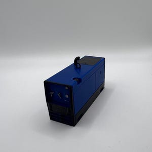 Peut inclure: Un g&eacute;n&eacute;rateur m&eacute;tallique bleu avec une poign&eacute;e noire et un panneau noir sur le dessus.
