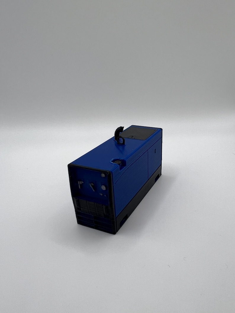 Peut inclure: Un g&eacute;n&eacute;rateur m&eacute;tallique bleu avec une poign&eacute;e noire et un panneau noir sur le dessus.