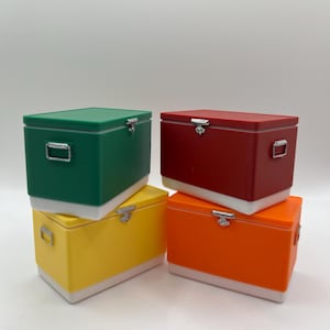 K&ouml;nnte beinhalten: Vier bunte, rechteckige K&uuml;hlboxen, die &uuml;bereinander gestapelt sind. Die K&uuml;hlboxen sind gr&uuml;n, rot, gelb und orange, jede mit wei&szlig;em Boden und Deckel. Sie haben silberne Verschl&uuml;sse und Griffe.
