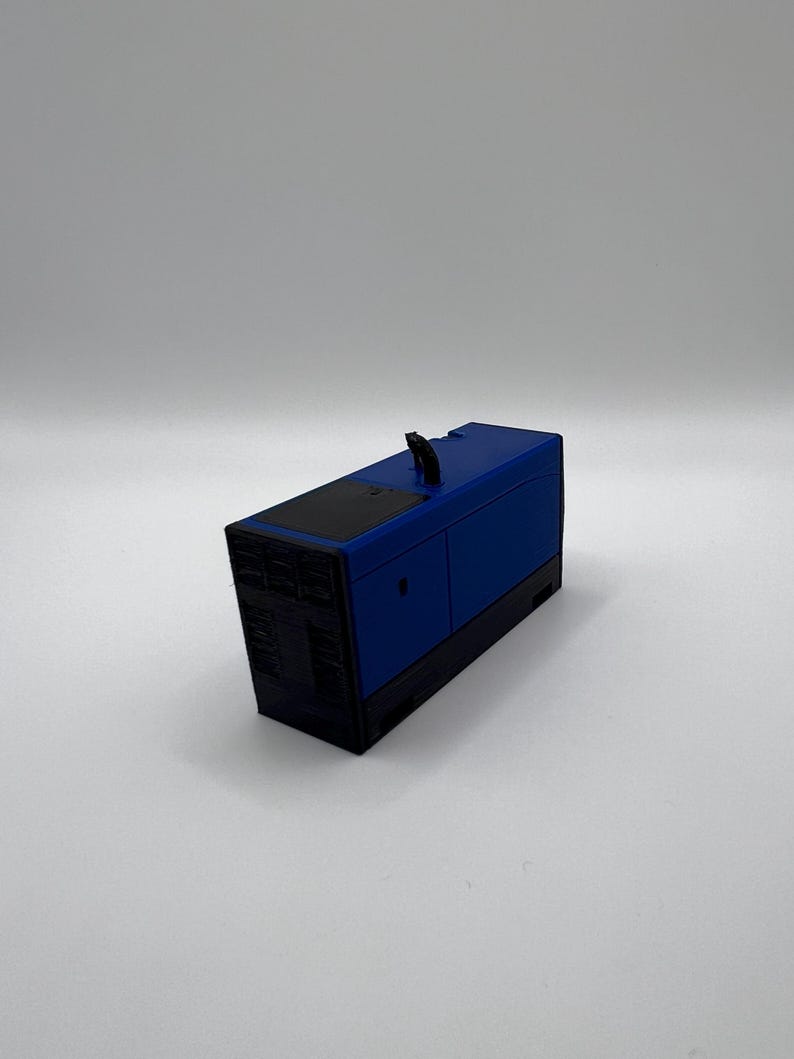 Peut inclure: Mod&egrave;le r&eacute;duit d'un g&eacute;n&eacute;rateur, de couleur bleue et noire. Le g&eacute;n&eacute;rateur a un dessus noir et un corps bleu avec une poign&eacute;e noire.