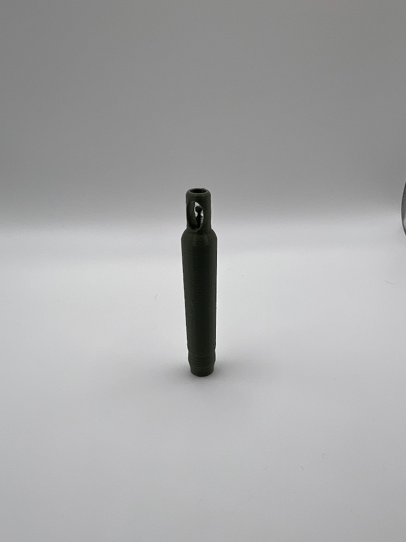 Peut inclure: Une bouteille en plastique vert fonc&eacute; avec un petit trou en haut. La bouteille mesure environ 12,5 cm de haut.