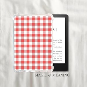 Könnte beinhalten: Auf der linken Seite des Bildes ist eine transparente Schutzhülle mit einem rot-weiß karierten Vichy-Muster zu sehen. Die Hülle befindet sich auf einem E-Reader mit Text auf dem Bildschirm. Die Worte "MAGIC & MEANING" stehen unten.