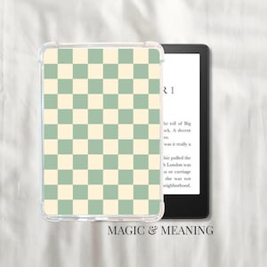 Peut inclure: Une coque de protection transparente pour liseuse avec un motif à carreaux vert et crème. L'e-reader affiche du texte. Les mots "MAGIC & MEANING" sont imprimés en bas.