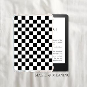 May include: A clear protective case for an e-reader featuring a black and white checkerboard pattern. The e-reader is black and displays text. The words "MAGIC & MEANING" are printed at the bottom.