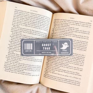 May include: A gray and black admission ticket with the text "GHOST TOUR" and a ghost graphic. The ticket also includes the text "ADMIT ONE" and "SPOOKS GUARANTEED".