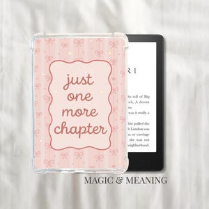 May include: A clear e-reader case featuring a pink design with bows and stripes. The case has a pink border with the words "just one more chapter". A black e-reader is visible behind the case, with text on the screen.