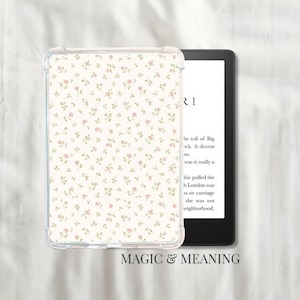 Op de afbeelding: Een doorzichtige beschermhoes voor een e-reader met een crèmekleurig bloemenpatroon. Het patroon heeft kleine roze bloemen en groene bladeren. De e-reader geeft tekst weer. De woorden "MAGIC & MEANING" staan onderaan.