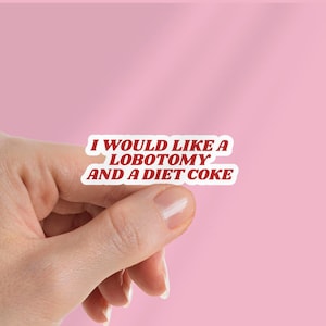 Puede incluir: Una pegatina blanca con el texto "I WOULD LIKE A LOBOTOMY AND A DIET COKE" en rojo, sostenida por una mano sobre un fondo rosa. La pegatina tiene un borde blanco y una fuente retro.
