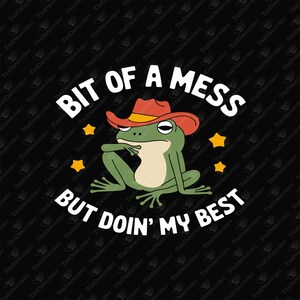 May include: A green frog wearing a red cowboy hat with white stars around it. The frog is sitting with its arms crossed and has a thoughtful expression. The text "Bit of a mess but doin' my best" is written in white letters below the frog.