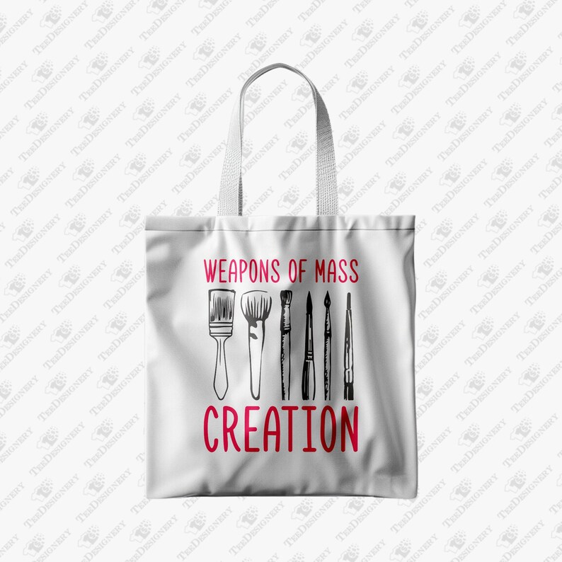 May include: White tote bag featuring the text "WEAPONS OF MASS CREATION" in red, with black illustrations of paintbrushes. The bag has a simple design with a rectangular shape and a handle for carrying.