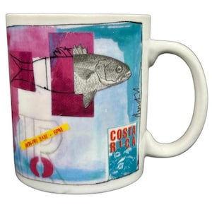 May include: White ceramic mug with a colorful design featuring a fish illustration, pink and blue geometric shapes, and the text "Costa Rica." A yellow sticker reads "MON-FRI 8AM - 6PM."